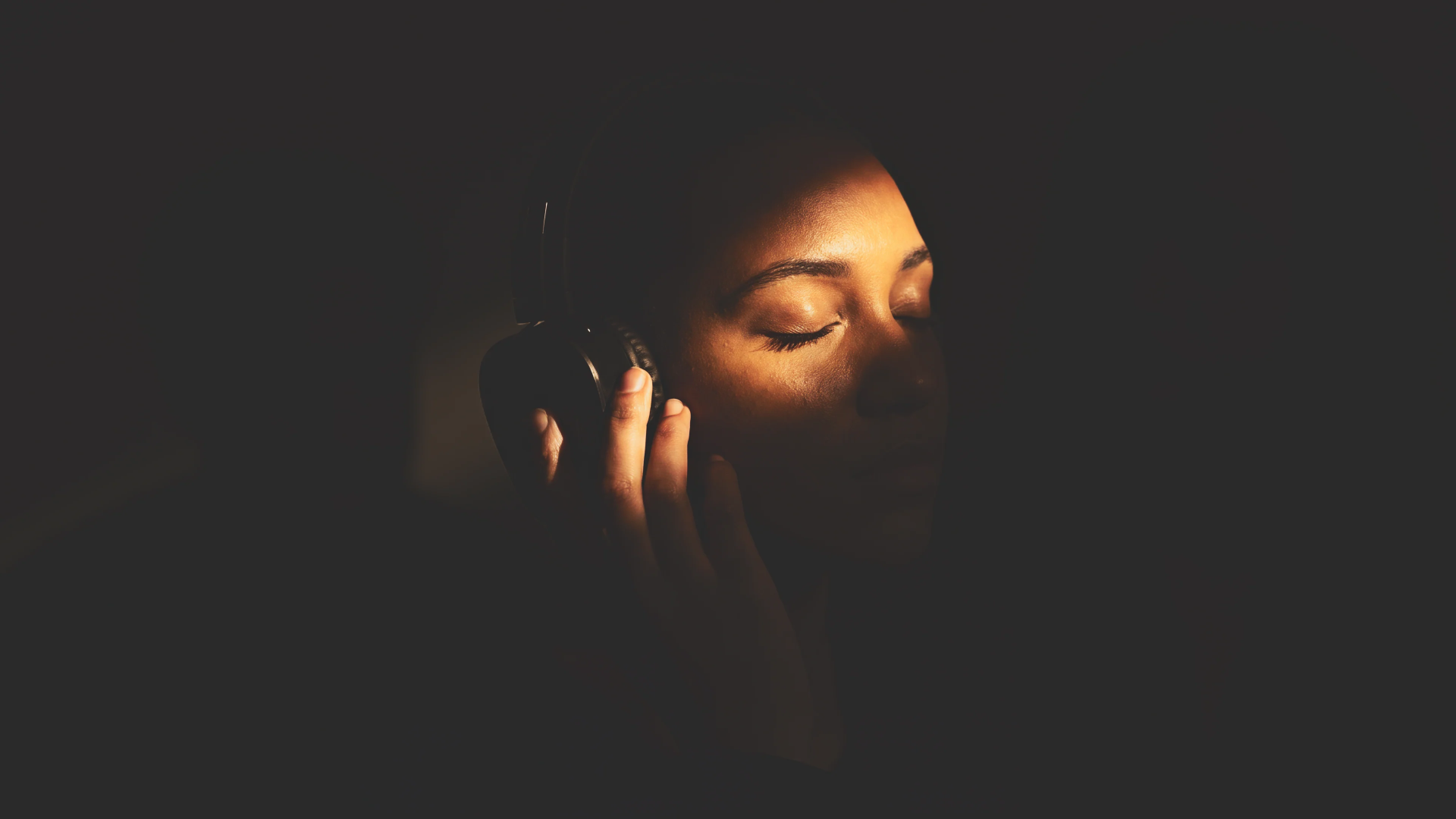 Small group in a candle-lit personal-audio wellness session at night.