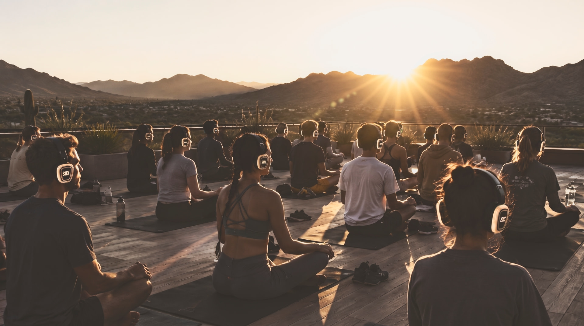 Sunrise rooftop meditation group in the Arizona desert wearing YARDSIIX personal-audio headphones.